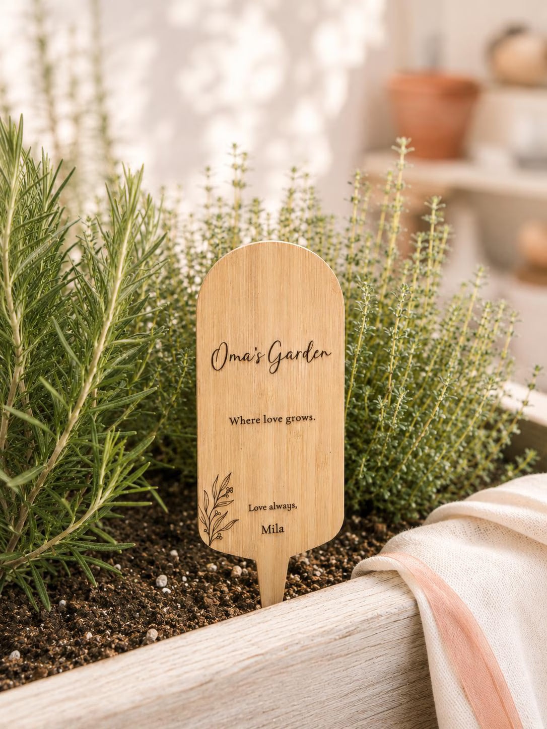 Personalised garden stake displayed with a garden plant